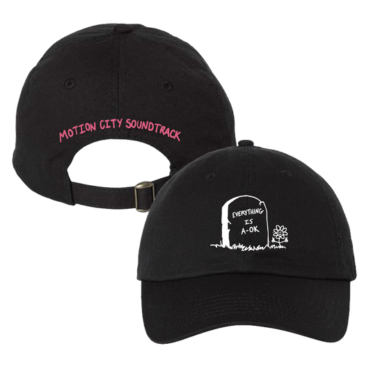 Black dad hat with white tombstone and flower graphic on the front. Motion City Soundtrack pink lettering embroidery on back.